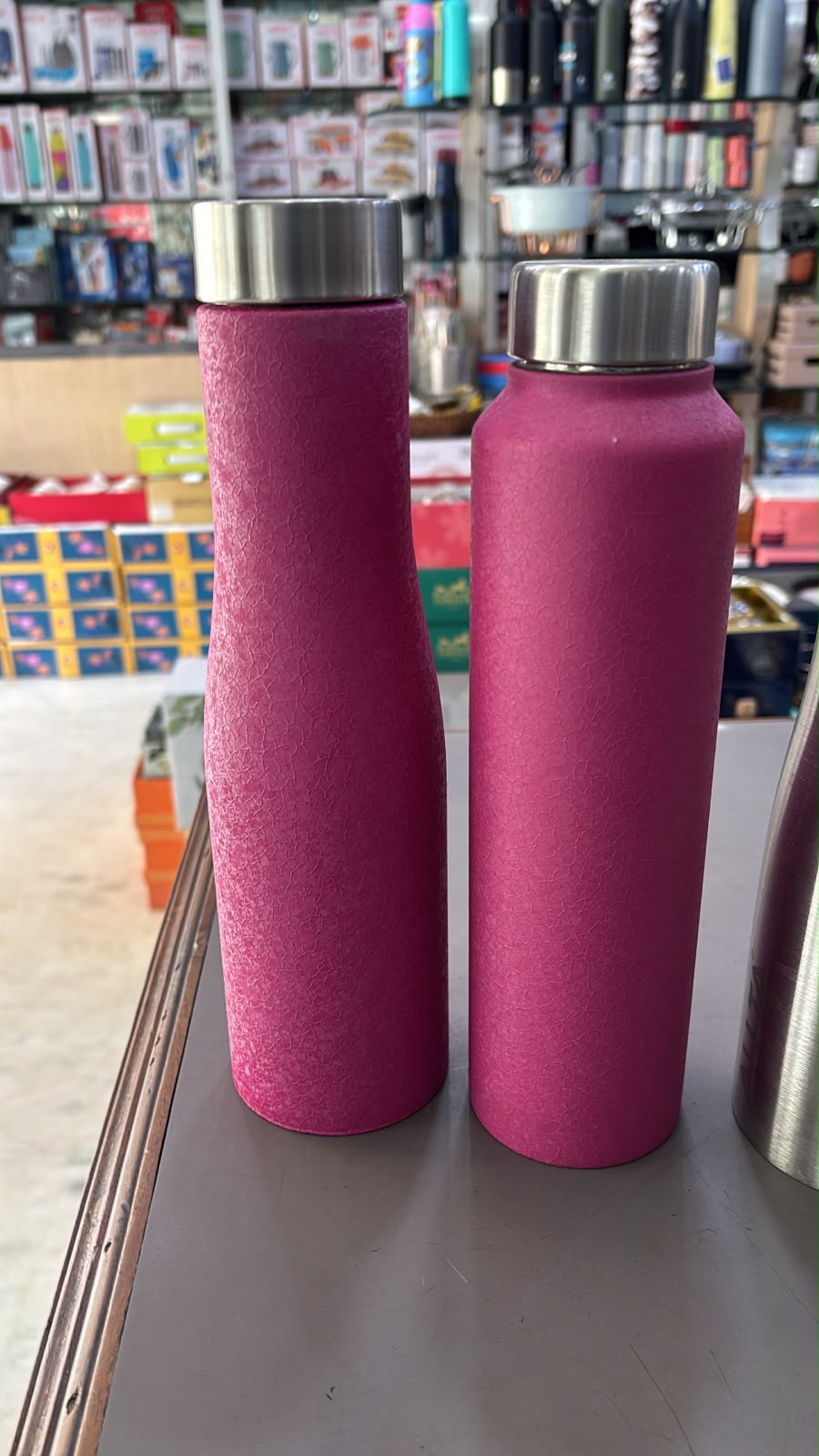 Two magenta textured steel bottles, one curved and one straight